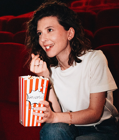 Consultante marketing freelance souriante avec du popcorn au cinéma