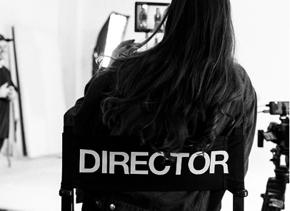 Directrice assise sur une chaise de réalisateur, prête à diriger une production.