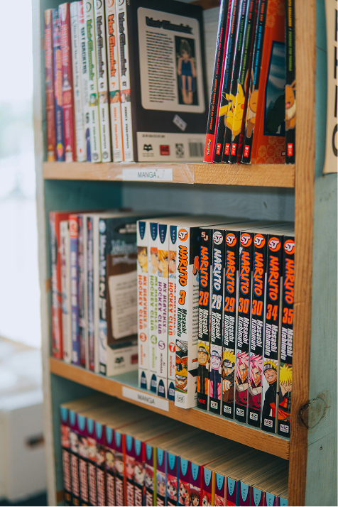 Étagères remplies de mangas et livres, dont des titres Naruto, pour le marketing expérientiel en entreprises.