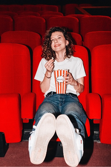 Consultante marketing souriante avec du popcorn au cinéma