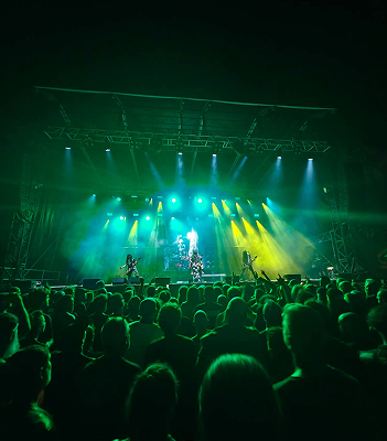 Concert de rock énergique sous des éclairages verts, public enthousiaste