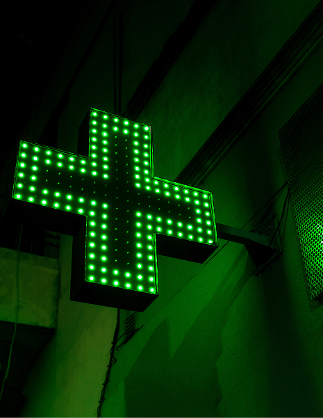 Croix verte lumineuse de pharmacie, symbole de santé pour les entreprises.